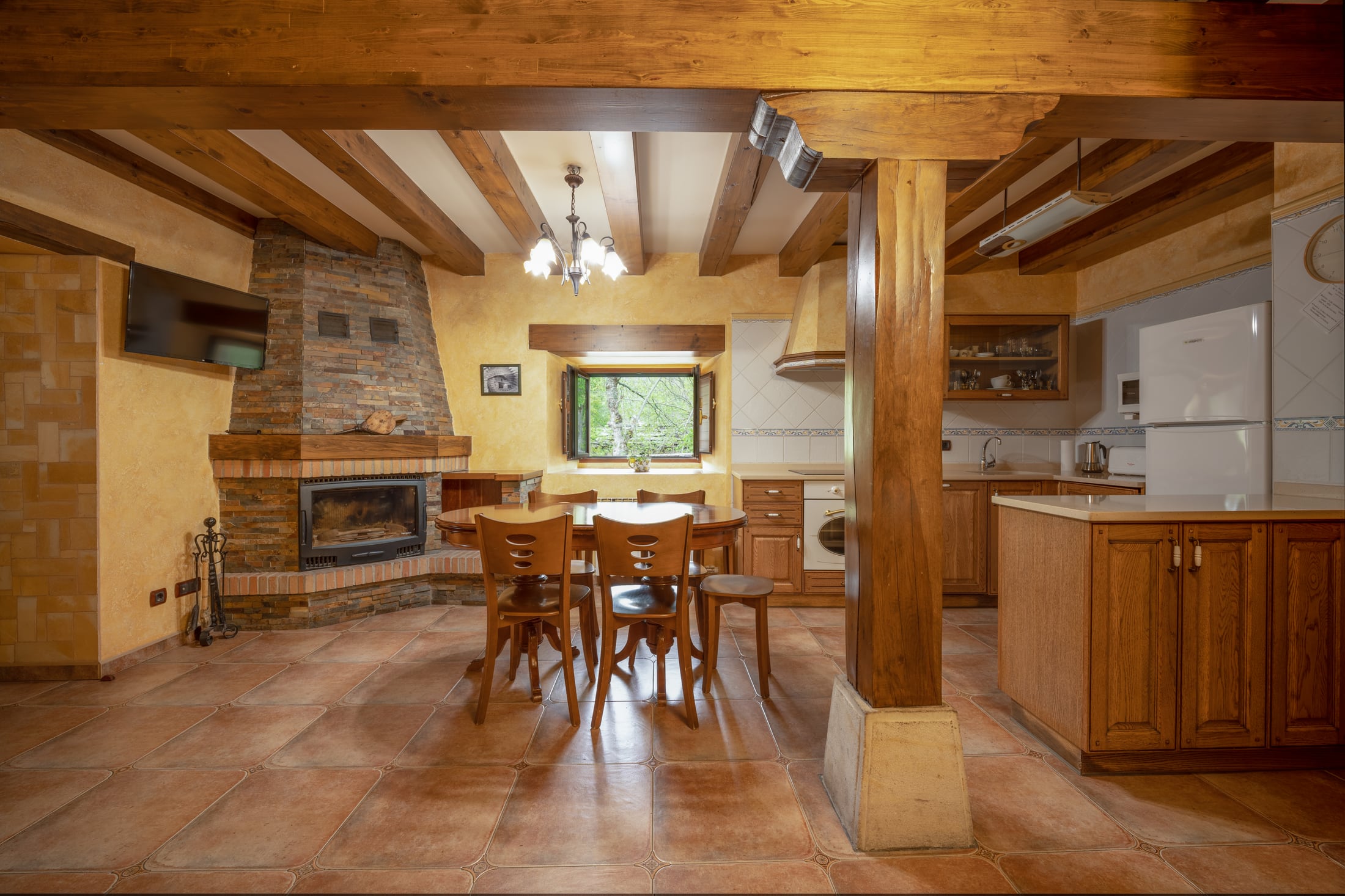 Salón y cocina rústicos con vigas de madera