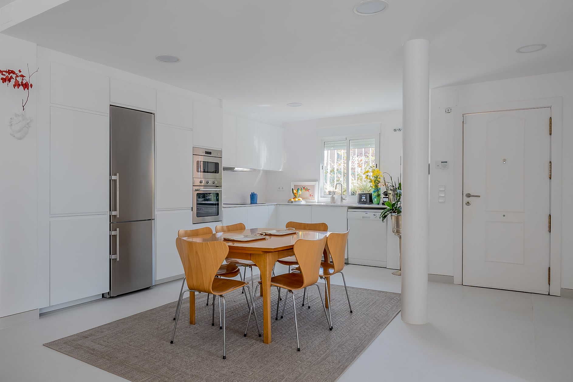 Cocina y comedor contemporáneos en tonos blancos
